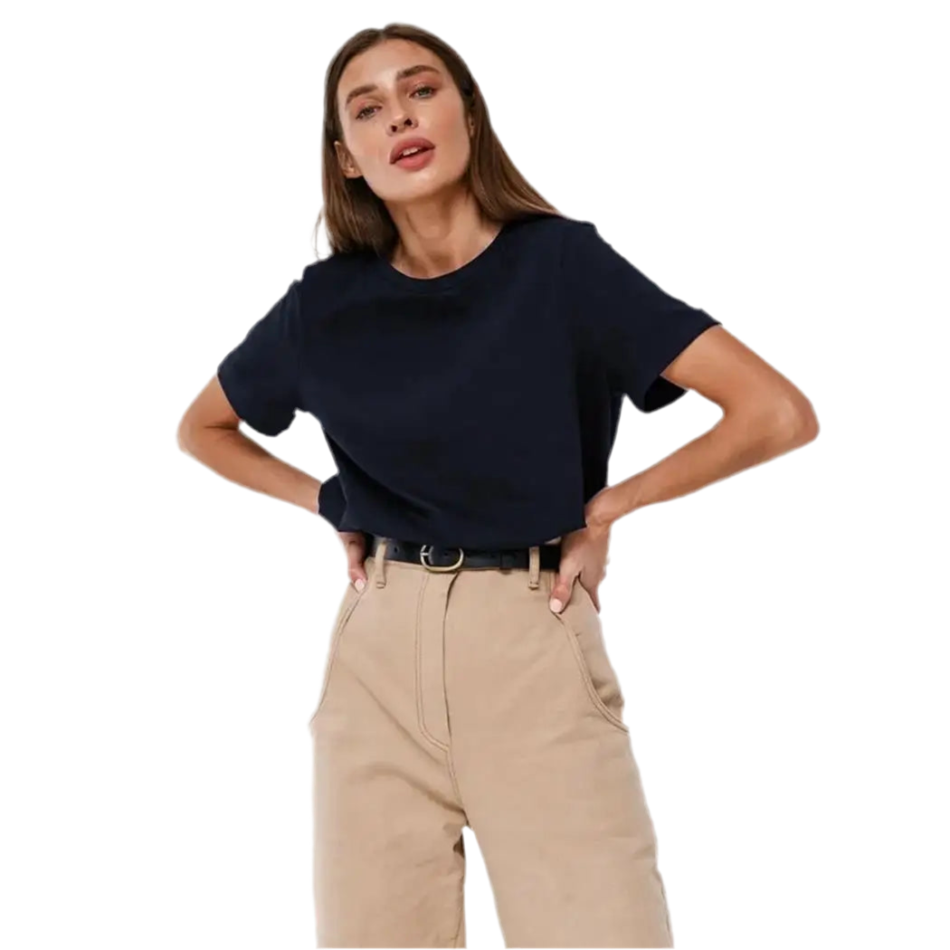 Woman wearing a navy blue top and beige pants on a white background