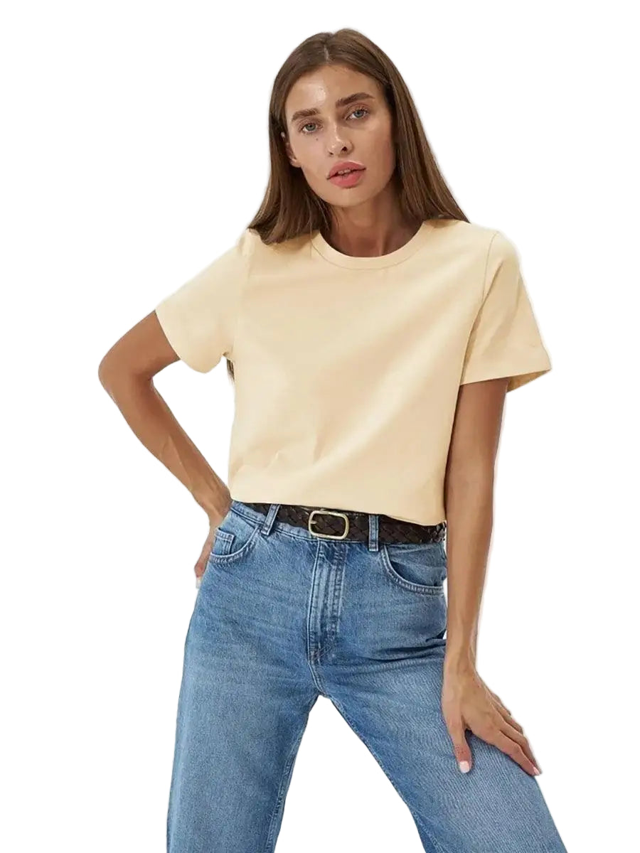 Woman wearing a beige t-shirt and blue jeans on a white background