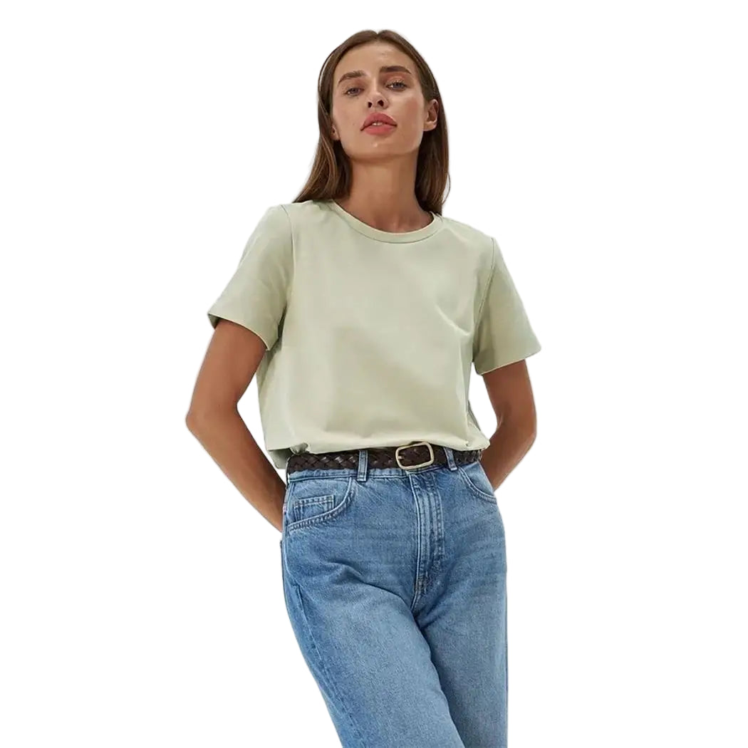 Woman wearing a light green t-shirt and blue jeans on a white background