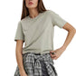 Woman wearing a light green t-shirt and plaid skirt on a white background
