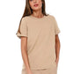 Woman wearing a beige t-shirt and pants on a white background