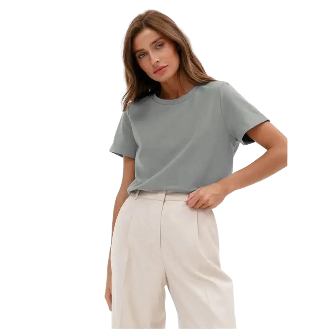 Woman wearing a light gray t-shirt and white pants on a white background