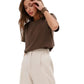 Woman wearing a brown top and beige pants on a white background