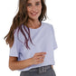Woman wearing a light purple t-shirt and gray pants against a white background