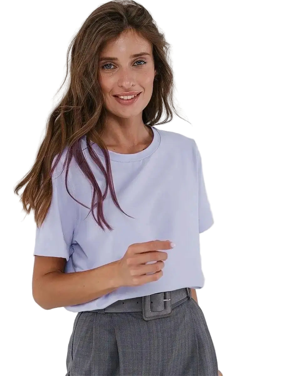 Woman wearing a light purple t-shirt and gray pants against a white background